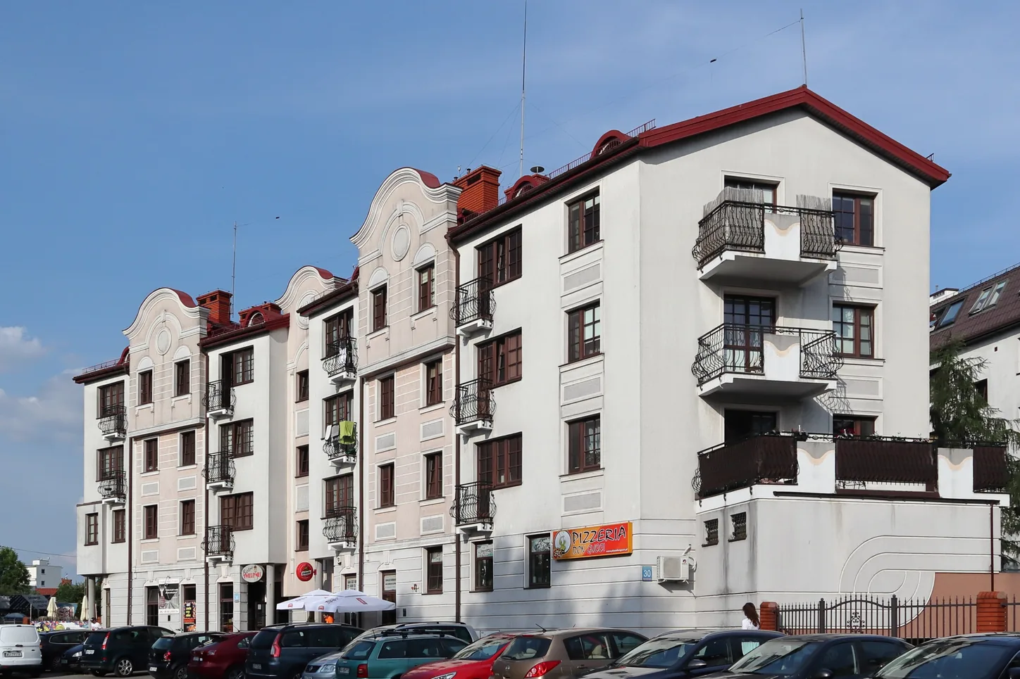 Kamienica z balkonami przy ulicy w Warszawie, zaparkowane samochody